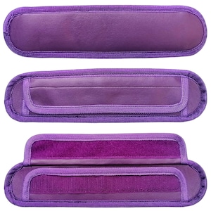 May include: Three purple fabric straps with velcro closures. The straps are designed to be used as handles for bags or other items.
