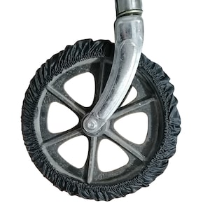 K&ouml;nnte beinhalten: Ein schwarzer Stoff-Radschutz mit elastischem Rand, der eng um ein dunkelgraues Kunststoffrad sitzt. Das Rad ist an einer gl&auml;nzenden, gebogenen Chrom-Metallgabel befestigt, die sich von der Mitte der Radnabe aus nach oben erstreckt.