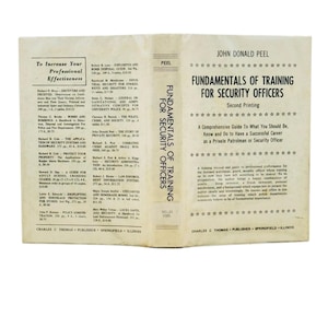 May include: An open book titled "Fundamentals of Training for Security Officers" by John Donald Peel. The cover is off-white with black text and a star design. The book is a second printing and a guide for a security career.