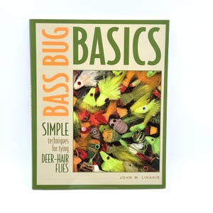 May include: A book titled "Bass Bug Basics" with a green and beige cover. The cover features the title in orange and green, and the subtitle "Simple techniques for tying deer-hair flies." The cover also displays a collection of colorful fishing flies.