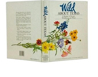 May include: A hardcover cookbook titled "Wild About Texas" with a floral bouquet illustration. The cover features the title in a script font and a subtitle "A Bouquet of Recipes, Wildflowers and Wines."