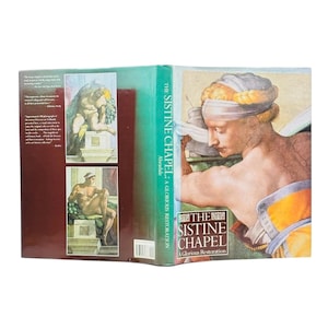 May include: A hardcover book titled "The Sistine Chapel: A Glorious Restoration" with a teal spine and images of Renaissance art. The cover features a detailed painting of a man with a head wrap. The back cover has two smaller art images.