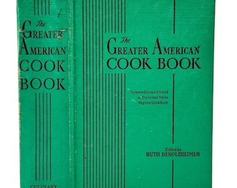 May include: A green hardcover book titled The Greater American Cook Book, edited by Ruth Berolzheimer. The cover features black vertical lines and text stating Former editions published as The United States Regional Cook Book, with spine text.