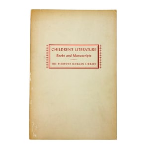 May include: A vintage book cover with a cream-colored background. The title "CHILDREN'S LITERATURE Books and Manuscripts" is printed in red within a rectangular frame. The text "THE PIERPONT MORGAN LIBRARY" is below.