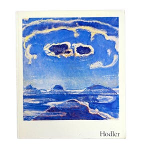 May include: A print of a landscape painting featuring a blue sky with cloud formations and a mountain range. The artwork is signed "Hodler" in the lower right corner. The painting has a white border.