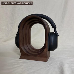 Könnte beinhalten: Ein Set aus drei Keramikbechern mit einer gesprenkelten, cremefarbenen Glasur. Jeder Becher hat ein anderes handgemaltes Design: ein blaues und grünes Blatt, eine gelbe Blume und eine rote Beere. Die Becher haben eine einfache, abgerundete Form.