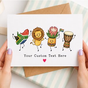 Puede incluir: Una tarjeta de felicitación blanca con cuatro personajes de dibujos animados: un mapa de Sudáfrica, un león, una flor protea en una maceta y un tambor djembe. Cada personaje tiene una cara sonriente y extremidades. Debajo, el texto Your Custom Text Here y un corazón rojo.