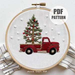 Könnte beinhalten: Roter LKW mit einem Weihnachtsbaum auf der Ladefläche, gestickt auf einem weißen Stoff mit einem Holzreifen. Der Hintergrund ist weiß mit weißen Schneeflocken. Der Text "PDF PATTERN" befindet sich in der oberen rechten Ecke.