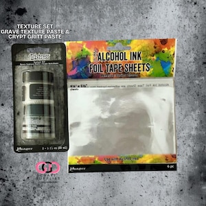 May include: A craft supplies product photo featuring a Texture Set with Grave Texture Paste & Crypt Gritt Paste, and Alcohol Ink Foil Tape Sheets. The foil tape sheets are 4.25" x 5.25". The packaging includes the brand name "Distress" and "Ranger".