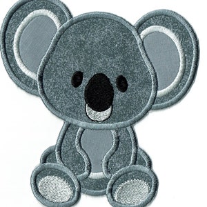 May include: A gray koala bear patch with a textured appearance. The koala has a black nose, black eyes, and white accents around the ears and mouth. The patch is embroidered with a white outline.