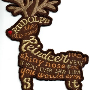 May include: A brown embroidered patch shaped like a reindeer with the words "Rudolph the red-nosed reindeer had a very shiny nose and if you ever saw him you would even say it glows" in a tan color.