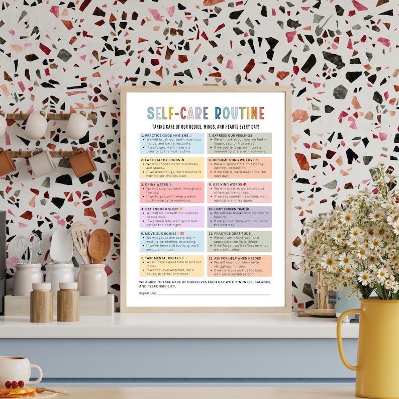 May include: A framed print titled "Self-Care Routine" with a beige wooden frame. The print features a list of self-care practices in a colorful design. The background is a terrazzo pattern with a yellow vase of white flowers.