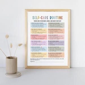May include: A framed print titled "Self-Care Routine" with colorful text. The print lists 12 self-care practices, including hygiene, healthy eating, and expressing feelings. The print is in a light wood frame and is displayed next to a vase.