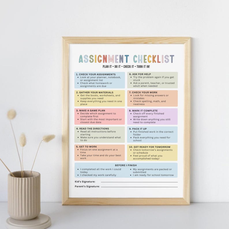 May include: A framed assignment checklist poster with a light wood frame. The poster features ten numbered steps in colorful pastel boxes, titled ASSIGNMENT CHECKLIST, with sections for kid and parent signatures at the bottom of the page.