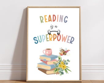 May include: A framed print with the text "READING is a SUPERPOWER" in colorful letters. The image includes a stack of books, a coffee cup, a bee with a cape, and flowers. The print is in a wooden frame.