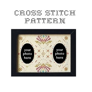 May include: Black framed cross stitch pattern with two oval photo openings. The cross stitch design features floral and geometric patterns in red, pink, blue, and yellow on a cream background. Text at the top reads "CROSS STITCH PATTERN."