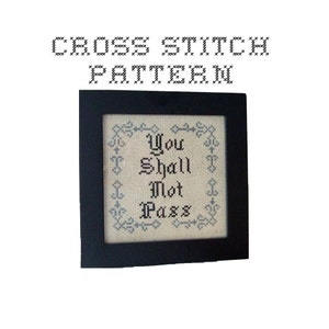 May include: Cross stitch pattern with a black frame and white fabric. The pattern reads "You Shall Not Pass" in black lettering with a blue floral border.