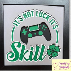 May include: A framed green and black graphic with a video game controller and the text "It's not luck it's skill" with a four-leaf clover.