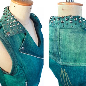 May include: Teal denim sleeveless vest with a studded collar. The vest has a zipper closure and a biker-style design.
