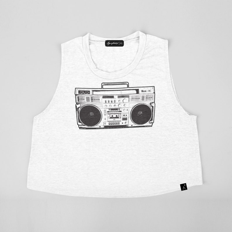 May include: White sleeveless crop top with a black and white graphic of a vintage boombox.