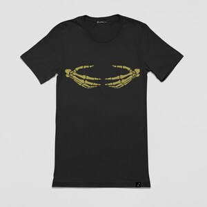 May include: Black t-shirt with a gold skeleton hand graphic on the front. The hands are facing each other and appear to be holding something.