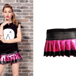 May include: A pink and black mini skirt with a pleated design and a black waistband. The skirt is made of a shiny, metallic fabric.