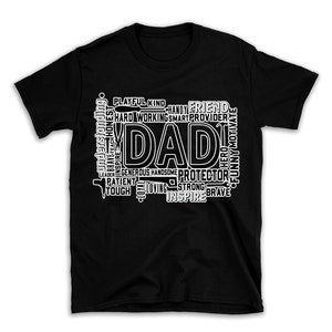 Peut inclure: T-shirt noir avec un design de nuage de mots blanc qui épelle "DAD" en grandes lettres. Le nuage de mots comprend des mots comme "gentil", "pratique", "ami", "protecteur", "fort", "courageux", "inspirer", "aimant", "patient", "dur", "généreux", "beau", "héros", "drôle", "motiver", "leader", "honnête", "courageux", "compréhensif", "joueur", "travailleur", "intelligent", "fournisseur".