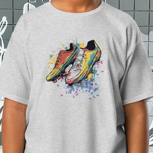 T-shirt chaussure de football - T-shirt graphique à crampons de football - T-shirt coloré pour le jour du match - T-shirt de soccer coloré avec éclaboussures - T-shirt à crampons de football - T-shirt de fan de football