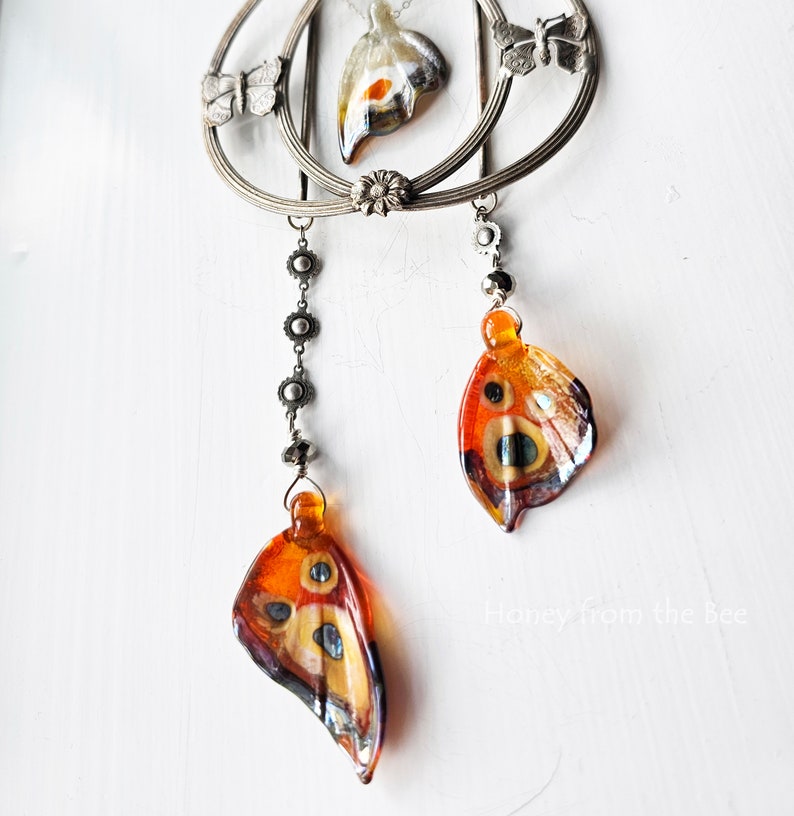 Lampwork butterfly wings in orange dangle from this statement necklace