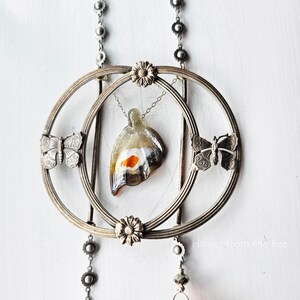 Antique buckle focal with butterflies and an art glass butterfly in grey and orange are the stars in this art necklace.