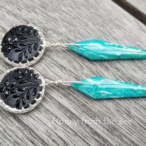 Antique black buttons are set in sterling silver and have Amazonite dangles in a gorgeous deep aqua in this pair of artisan earrings