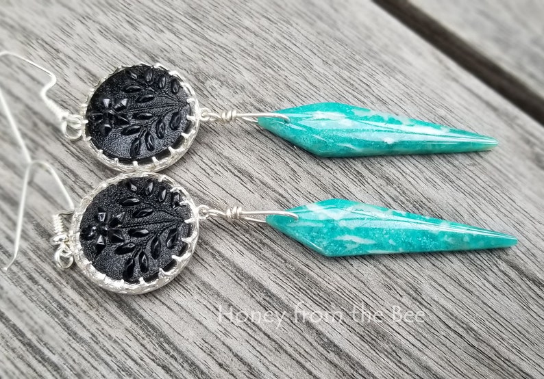 Antique black buttons are set in sterling silver and have Amazonite dangles in a gorgeous deep aqua in this pair of artisan earrings