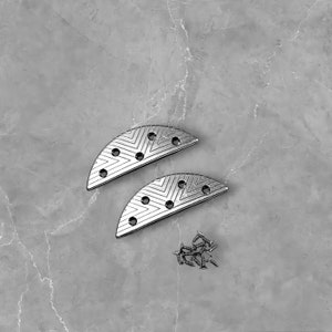 May include: Two silver metal shoe heel protectors with a geometric pattern and a set of silver screws.