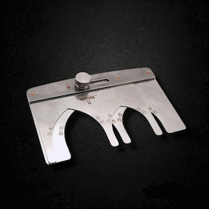 May include: A silver metal gauge with a knob and five different sized slots for measuring. The slots are labeled with measurements in inches: 35-40, 30-35, 30-35, 25-30, and 25-30.