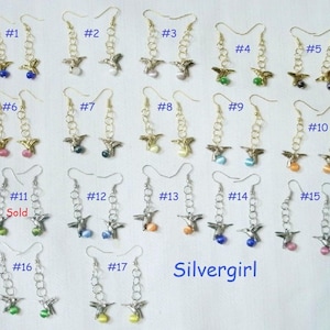 May include: A set of 17 pairs of silver hummingbird earrings with colorful glass beads. The earrings are numbered 1 through 17.  Earrings #11 are marked as "Sold".
