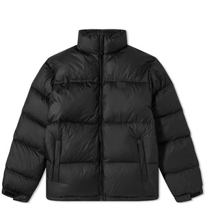 Puede incluir: Una chaqueta acolchada de color negro sólido con cuello alto, cierre de cremallera frontal completo y paneles horizontales acolchados. La prenda incluye dos bolsillos laterales y mangas largas con puños ajustables para un diseño sencillo.