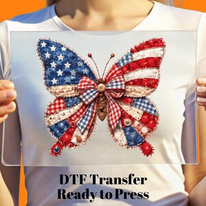 May include: A patriotic butterfly design with red, white, and blue patchwork wings, featuring stars and stripes. The butterfly has a wooden button and bead details. The text "DTF Transfer Ready to Press" is at the bottom.