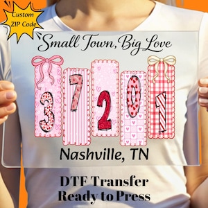 May include: A clear rectangular sign featuring the text "Small Town, Big Love" and the numbers "37201" in a pink and red design. The sign also includes the text "Nashville, TN" and "DTF Transfer Ready to Press".