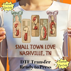 May include: A clear rectangular sign with the text "SMALL TOWN LOVE NASHVILLE, TN". The sign displays the numbers 37209 in a decorative style with bows and a patchwork design. The text "DTF Transfer Ready to Press" is also visible.