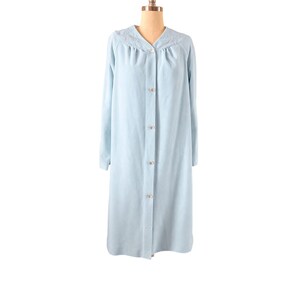 May include: A light blue, long-sleeved robe with a button-down front. The robe features a V-neckline with delicate embroidered detailing in pink and white. The robe is displayed on a mannequin.