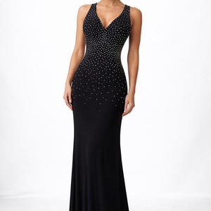 May include: A black formal gown with a V-neckline and a floor-length skirt. The bodice is embellished with small, sparkling accents that fade down the dress. The dress is sleeveless and form-fitting, suitable for special occasions.
