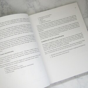 Peut inclure: Livre ouvert avec des pages blanches et du texte noir. Le livre est intitul&eacute; "Guidelines for Creative Journal-keeping". Le texte traite de l'importance de la tenue d'un journal et fournit des directives pour la tenue d'un journal cr&eacute;atif.