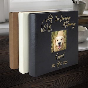 May include: A black photo album with a golden retriever illustration and the words "In loving Memory" and "Cupid". The album includes a photo of a golden retriever and the years 2012-2025.