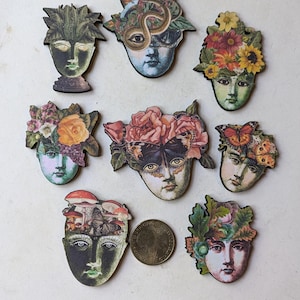 May include: Nine wooden decorative ornaments featuring faces with various floral and nature-themed designs. The ornaments are painted with vibrant colors and intricate details, including butterflies, flowers, and leaves.
