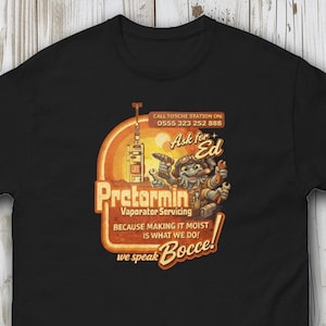May include: Black t-shirt featuring a retro-style graphic with the text "Pretormin Vaporator Servicing" and the phrase "Because making it moist is what we do!" The design includes a cartoon character and the words "Ask for Ed."