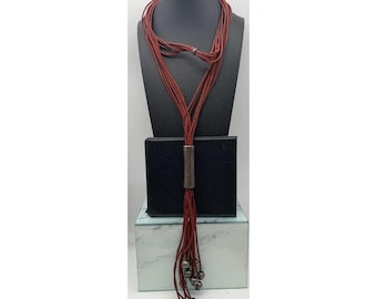 Collar Uno de 50, tono plata envejecida, colgante largo de cuero con múltiples cordones.