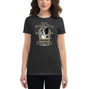 May include: A dark heather grey women's t-shirt with a vintage-style illustration of a Boston Terrier dog. The illustration is surrounded by a gold oval frame with the text "Old Stink Eye Pure Rye Whiskey" in a stylized font.