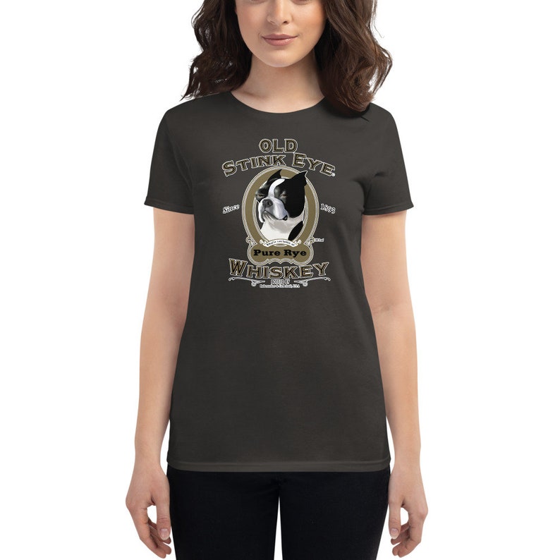 May include: A dark gray women's t-shirt with a vintage-style illustration of a Boston Terrier dog. The illustration is surrounded by text that reads "Old Stink Eye Pure Rye Whiskey".