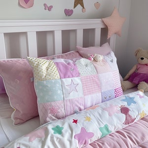 May include: A white bed with pink and white patterned pillows and a white and pink star patterned bolster pillow. The bed is decorated with pink and white stars and a pink butterfly.