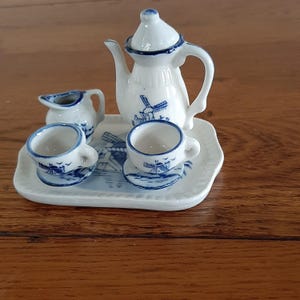 May include: A set of three ceramic mugs with a speckled, matte finish in cream, light grey, and dark grey. Each mug has a simple, minimalist design, suitable for coffee or tea.